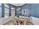 Charming dining room with blue walls, wainscoting, and a rustic wood table at 308 Kissengen Park Dr, Bartow, FL 33830