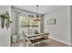 Bright dining room with a rustic table, chandelier lighting, and a large window offering natural light at 308 Kissengen Park Dr, Bartow, FL 33830