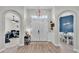 Inviting entryway with wood-look flooring, arched openings, and a stylish light fixture at 308 Kissengen Park Dr, Bartow, FL 33830