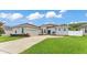 Home featuring a gray exterior, lovely front yard landscaping, a two-car garage, and a gray roof at 308 Kissengen Park Dr, Bartow, FL 33830