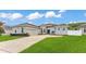Exterior view of a home with a well-kept lawn, attached garage, and tidy landscaping along the driveway at 308 Kissengen Park Dr, Bartow, FL 33830