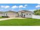 Charming home exterior showcasing a well-manicured lawn, beautiful landscaping, and an attached two-car garage at 308 Kissengen Park Dr, Bartow, FL 33830