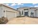 Home featuring a gray exterior, lovely front yard landscaping, a two-car garage, and a gray roof at 308 Kissengen Park Dr, Bartow, FL 33830