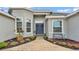 Close up of a front porch with colorful flower beds, double door entry with wreaths, and decorative flower pots at 308 Kissengen Park Dr, Bartow, FL 33830