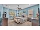 Light blue main bedroom featuring a king bed, ceiling fan, carpet and a cushioned bench at 308 Kissengen Park Dr, Bartow, FL 33830