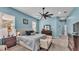 Light blue main bedroom featuring a king bed, ceiling fan, carpet and a cushioned bench at 308 Kissengen Park Dr, Bartow, FL 33830