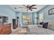 Blue main bedroom featuring a king bed, ceiling fan, carpet and a view to the outside at 308 Kissengen Park Dr, Bartow, FL 33830