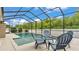 The screened-in pool area features outdoor seating for dining and relaxing by the pool at 308 Kissengen Park Dr, Bartow, FL 33830