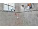 Walk-in shower with gray tile, shelving, and glass door at 308 Kissengen Park Dr, Bartow, FL 33830