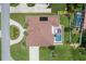 An aerial view shows a private backyard with a screened pool, patio area and lush lawn at 328 Hamilton Shores Ne Dr, Winter Haven, FL 33881