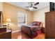Comfortable bedroom with a wooden bed frame, ceiling fan, and wood flooring at 328 Hamilton Shores Ne Dr, Winter Haven, FL 33881