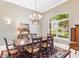 Formal dining room with a large window, chandelier, and elegant decor at 328 Hamilton Shores Ne Dr, Winter Haven, FL 33881