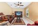 Inviting living room with a brown leather sofa, media center, and ceiling fan at 328 Hamilton Shores Ne Dr, Winter Haven, FL 33881