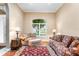 Cozy living room featuring comfortable floral seating, wood floors, and a large window with natural light at 328 Hamilton Shores Ne Dr, Winter Haven, FL 33881