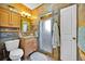 Well-lit bathroom with tile walls, wood cabinetry, glass-enclosed shower, and decorative mirror at 345 Avenue J Se, Winter Haven, FL 33880