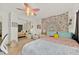 Bright bedroom with light walls, decorative tapestry, mirrored closet, and ceiling fan with floral design at 345 Avenue J Se, Winter Haven, FL 33880