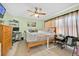 Cozy bedroom featuring light green walls, ceiling fan, and a comfortable bed with natural light at 345 Avenue J Se, Winter Haven, FL 33880