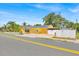 Charming yellow home with white picket fence and a long driveway, showcasing curb appeal at 345 Avenue J Se, Winter Haven, FL 33880