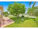 Grassy side yard showcasing a mature tree, vintage lamppost, and partial view of the yellow home at 345 Avenue J Se, Winter Haven, FL 33880
