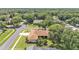 A bird's-eye view of a property with a well-maintained lawn, mature trees, and a screened-in pool area at 3717 Tigereye Ct, Mulberry, FL 33860