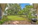 Expansive backyard showcasing lush landscaping, mature trees, and secure black wrought iron fencing at 3717 Tigereye Ct, Mulberry, FL 33860