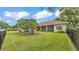Fully fenced backyard highlighting a sprawling lawn, mature trees, and a well-maintained exterior at 3717 Tigereye Ct, Mulberry, FL 33860