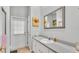 Bright bathroom with a gray counter top, a framed mirror, and an exit door to the outdoor backyard at 3717 Tigereye Ct, Mulberry, FL 33860