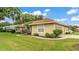 Tan home featuring well-kept lawn and garden, white framed windows, and a walkway that leads to the front door at 3717 Tigereye Ct, Mulberry, FL 33860