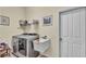 Bright laundry room with modern washer and dryer, utility sink, and convenient storage shelving at 3717 Tigereye Ct, Mulberry, FL 33860