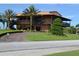 Two-story clubhouse with a second-story balcony, surrounded by palm trees and lush landscaping at 4105 Limerick Dr, Lake Wales, FL 33859