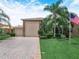 Charming two-story home features a stone facade, well-manicured lawn, and palm trees at 4105 Limerick Dr, Lake Wales, FL 33859