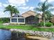 Inviting home exterior featuring a tranquil pond, lush landscaping, and screened lanai for peaceful outdoor enjoyment at 4105 Limerick Dr, Lake Wales, FL 33859