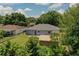 Aerial view of a home featuring a spacious backyard, mature trees, and a charming exterior in a desirable neighborhood at 411 Red Hawk Loop, Winter Haven, FL 33880