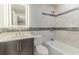 Bathroom boasts lighted mirror, gray vanity, toilet, and tiled bathtub/shower combination at 411 Red Hawk Loop, Winter Haven, FL 33880