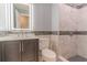 Bathroom features lighted mirror, gray vanity, toilet, and tiled shower with mosaic accents at 411 Red Hawk Loop, Winter Haven, FL 33880