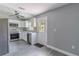 Updated kitchen featuring white cabinets, stainless steel appliances, gray backsplash, and wood-look floors at 411 Red Hawk Loop, Winter Haven, FL 33880