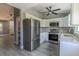 Updated kitchen features white cabinets, stainless steel appliances, gray backsplash, and wood-look floors at 411 Red Hawk Loop, Winter Haven, FL 33880