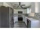 Updated kitchen with white cabinets, stainless steel appliances, granite countertops, and wood-look floors at 411 Red Hawk Loop, Winter Haven, FL 33880