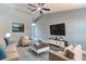 Staged living room with vaulted ceiling, modern furniture, TV, stylish rug, and wood-look flooring at 411 Red Hawk Loop, Winter Haven, FL 33880