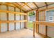 Inside of a shed featuring wood framing, built-in shelves, workbench and a view to the back yard at 411 Red Hawk Loop, Winter Haven, FL 33880