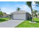 Home featuring a two-car garage with mature landscaping at 419 Wellesly Dr, Davenport, FL 33897