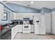 Well-lit kitchen features white cabinetry, appliances, and tile flooring at 419 Wellesly Dr, Davenport, FL 33897