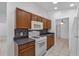 Cozy kitchen with wooden cabinets, mosaic tile backsplash, and white appliances at 452 Lake Suzanne Dr, Lake Wales, FL 33859