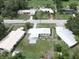 An aerial shot of home with a white roof in a neighborhood with lush greenery at 455 Manor Dr, Bartow, FL 33830