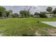 Spacious backyard with green grass and wooden sheds in the background, offering plenty of room for outdoor activities at 455 Manor Dr, Bartow, FL 33830