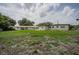 Large backyard showcasing the property's spacious outdoor area and surrounding greenery, with various structures in the distance at 455 Manor Dr, Bartow, FL 33830