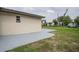 Exterior view showing back of property with a gray concrete patio that extends into the lawn at 455 Manor Dr, Bartow, FL 33830