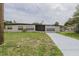 Charming one-story home featuring a newly painted driveway and lush green lawn at 455 Manor Dr, Bartow, FL 33830
