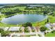 An aerial view shows the house with lake access, a nearby pool, and mature landscaping at 464 Lake Suzanne Dr, Lake Wales, FL 33859