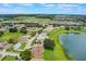 Aerial view of a home in a neighborhood with a lake, green spaces, and solar panels at 464 Lake Suzanne Dr, Lake Wales, FL 33859